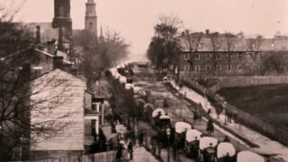 Soldiers and wagons marching through a city in The Civil War