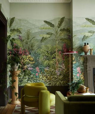 living room with large tropical wallpaper mural and green velvet furnishings