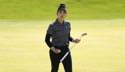 Lucy Li holds her putter as she walks across the green