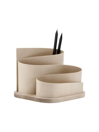 A wavy, handcarved desk organizer in wood features a cream structure and two black-bodied pencils.