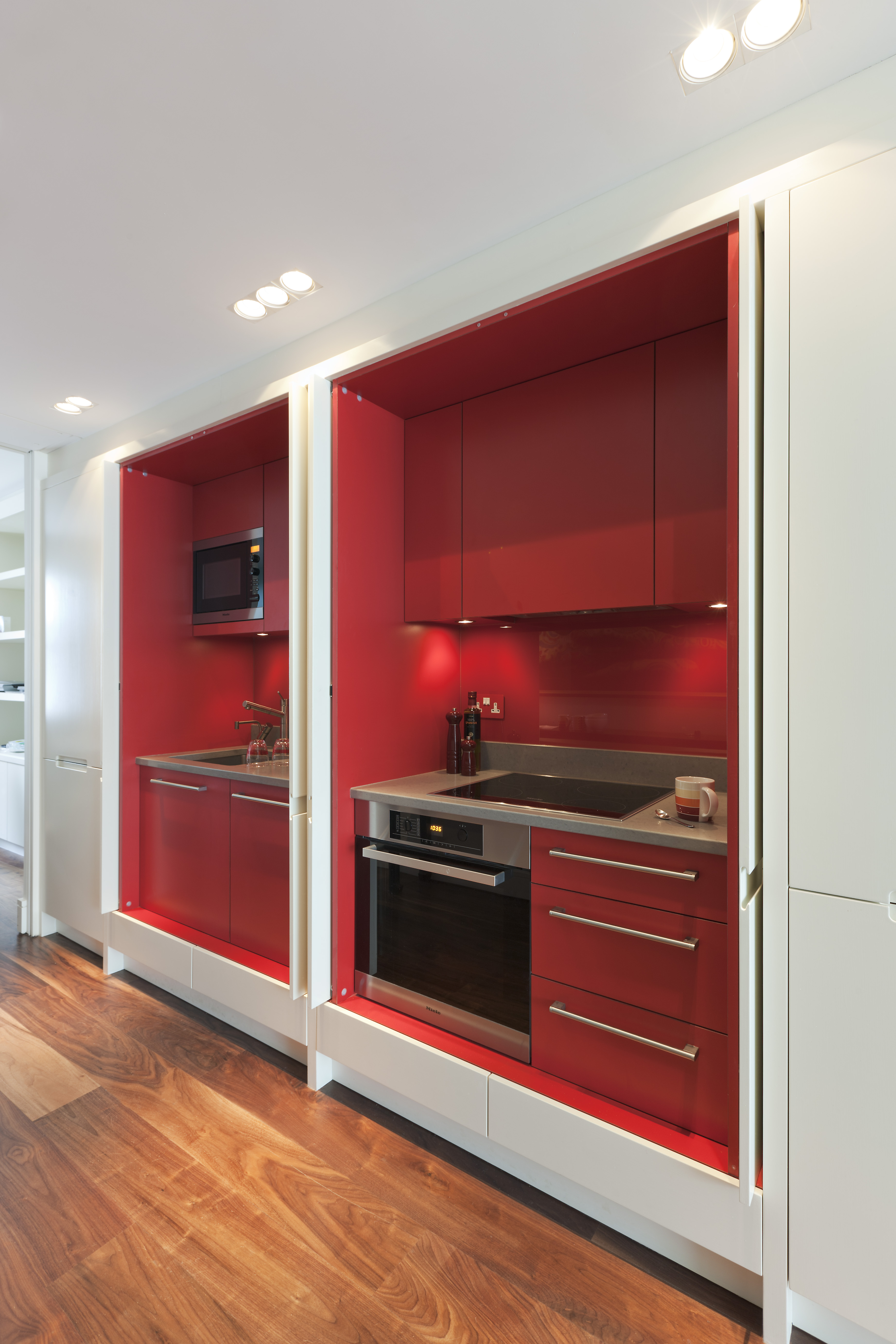 Red laminate kitchen housed behind doors