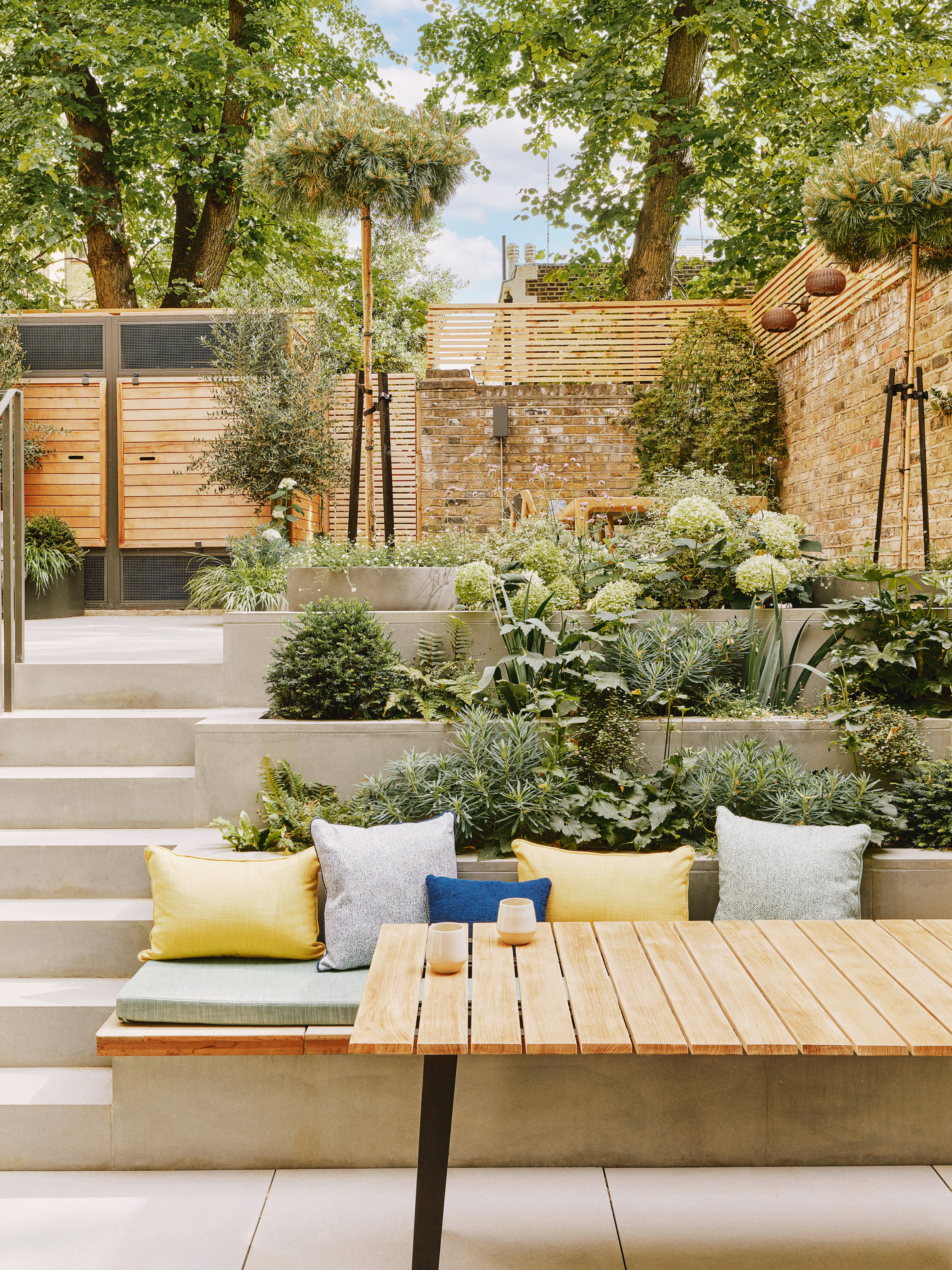 Tiered stone planting with steps leading alongside and built-in bench at bottom