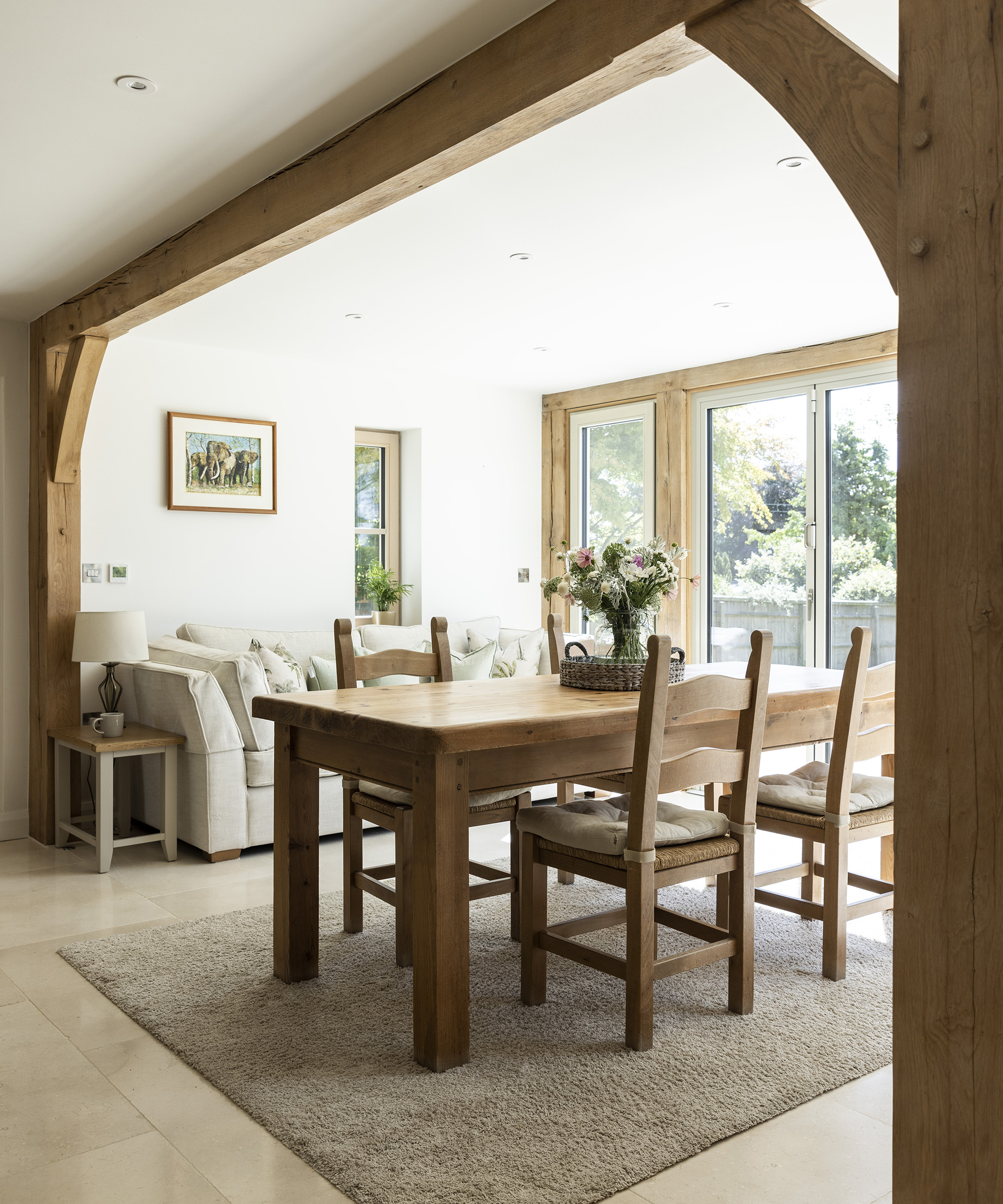 A dining room in a timber frame home with exposed oak beams