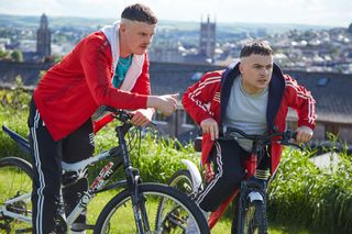 Jock and Conor on their bikes with Cork City in the background