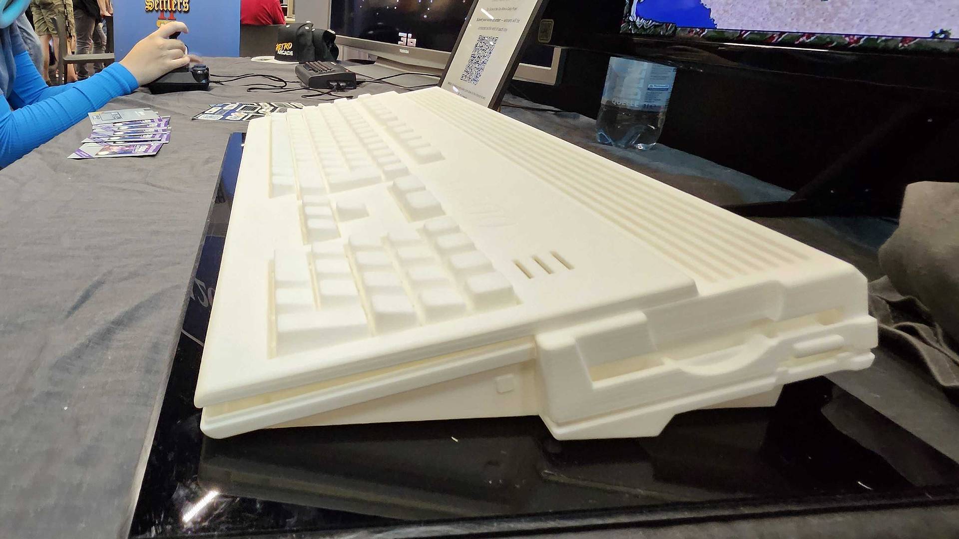 Side view of White Amiga A1200 prototype on black table at Gamescom 2025.