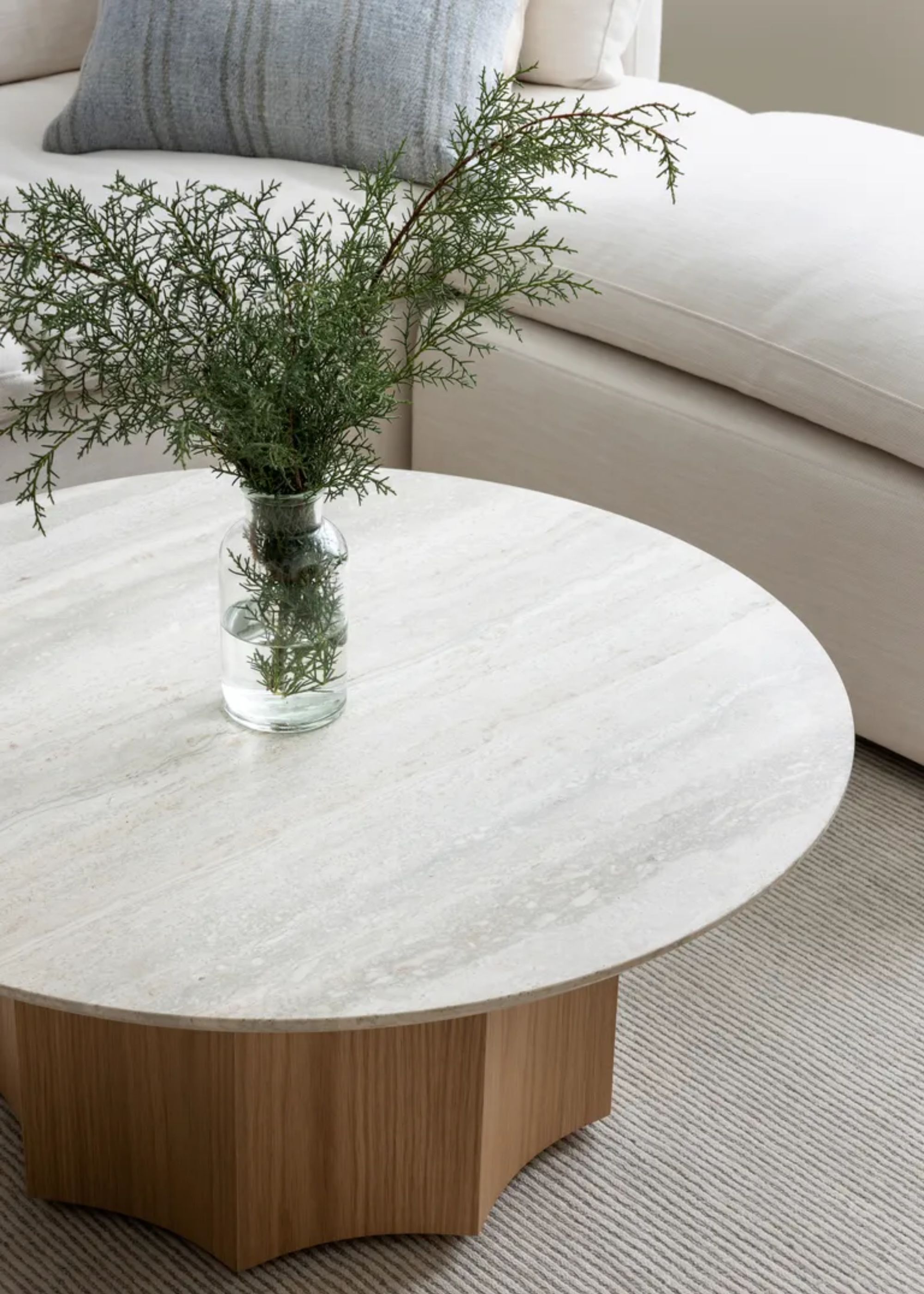 A close-up of a coffee table with a vase of sprigs