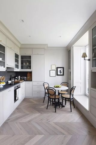 Small kitchen with herringbone flooring and round dining table