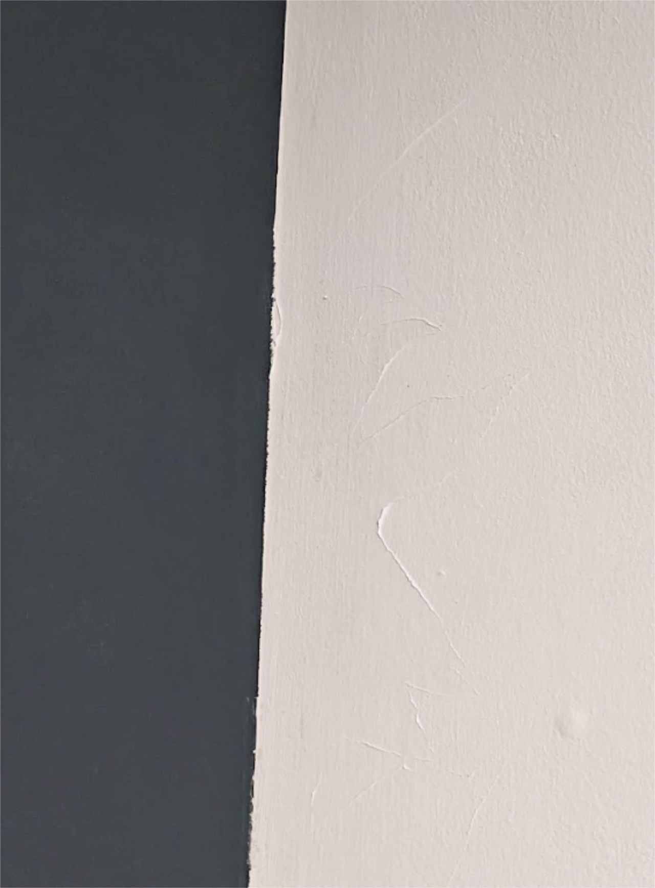 Paint peeling off a white wall