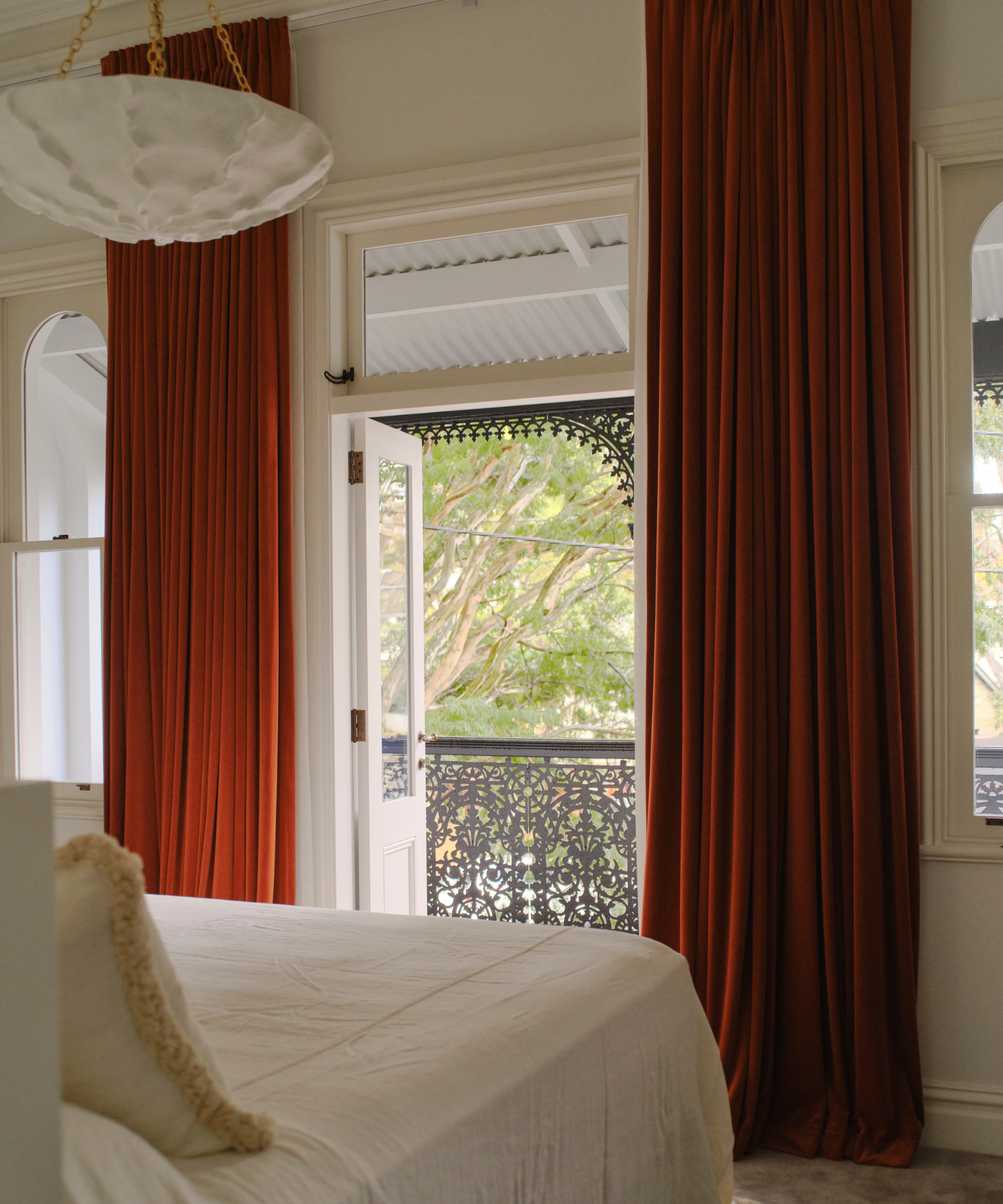 a bedroom with dramatic long curtains in a shade of red