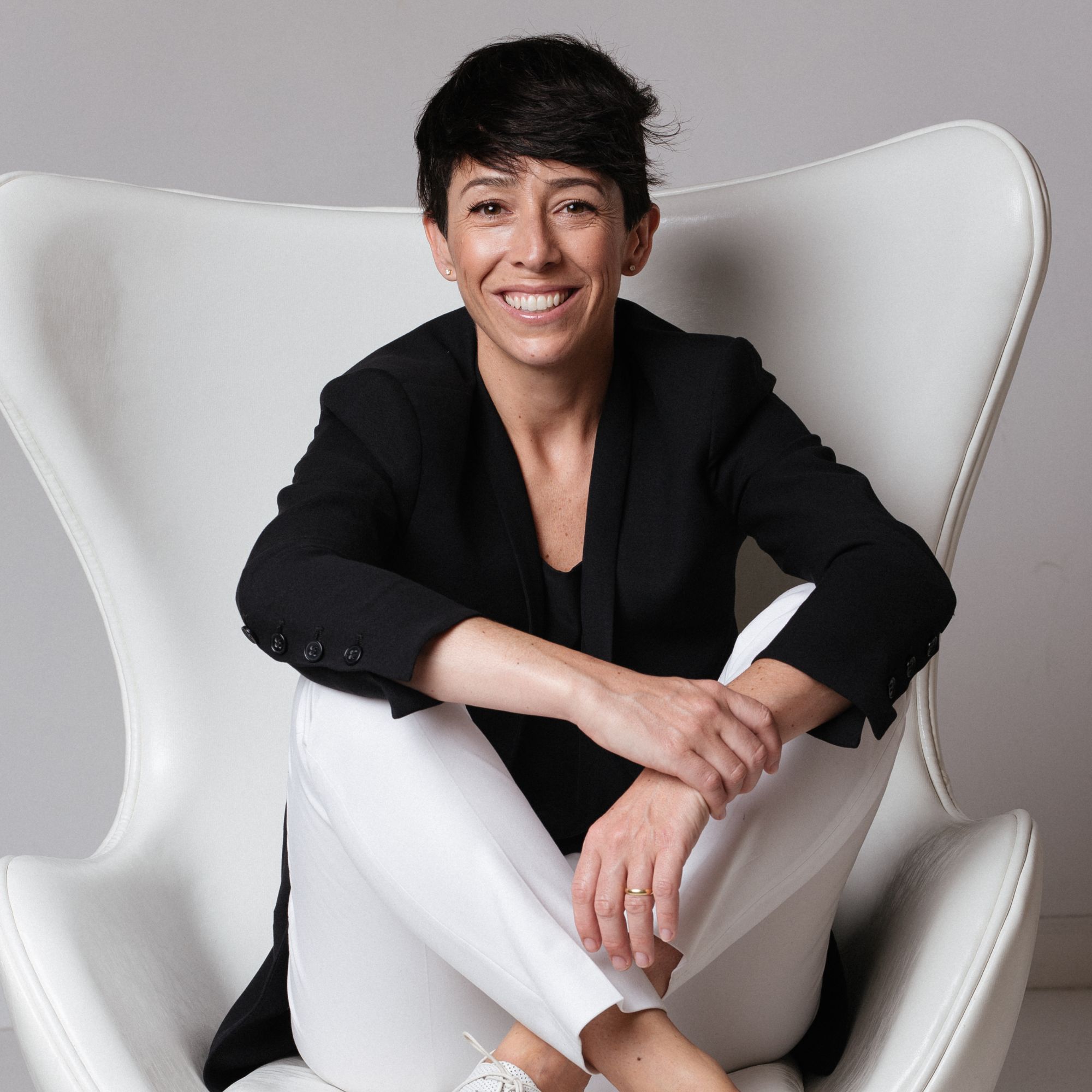 An image of Gala Magri&ntilde;&aacute; sitting in a large white chair against a white background.