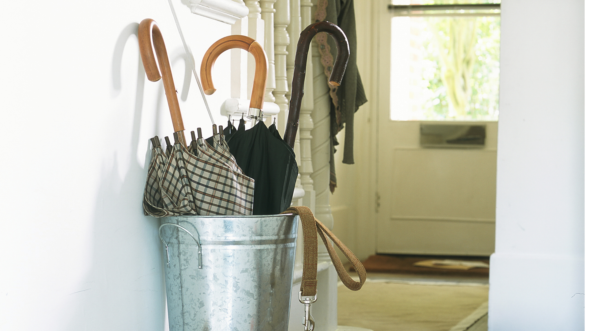 Umbrella stand in a hallway next to the stairs