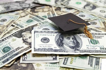 Graduation cap sitting on top of U.S. $100 bills and $20 bills