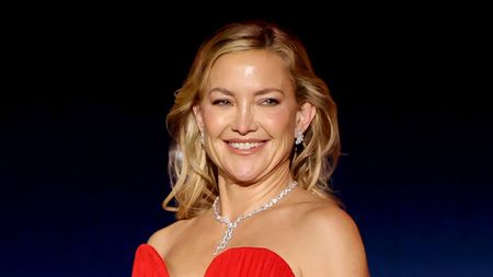 Kate Hudson attends the 2026 Critics Choice awards and wears red in support of Song Sung Blue. She also has on a diamond necklace and earrings.