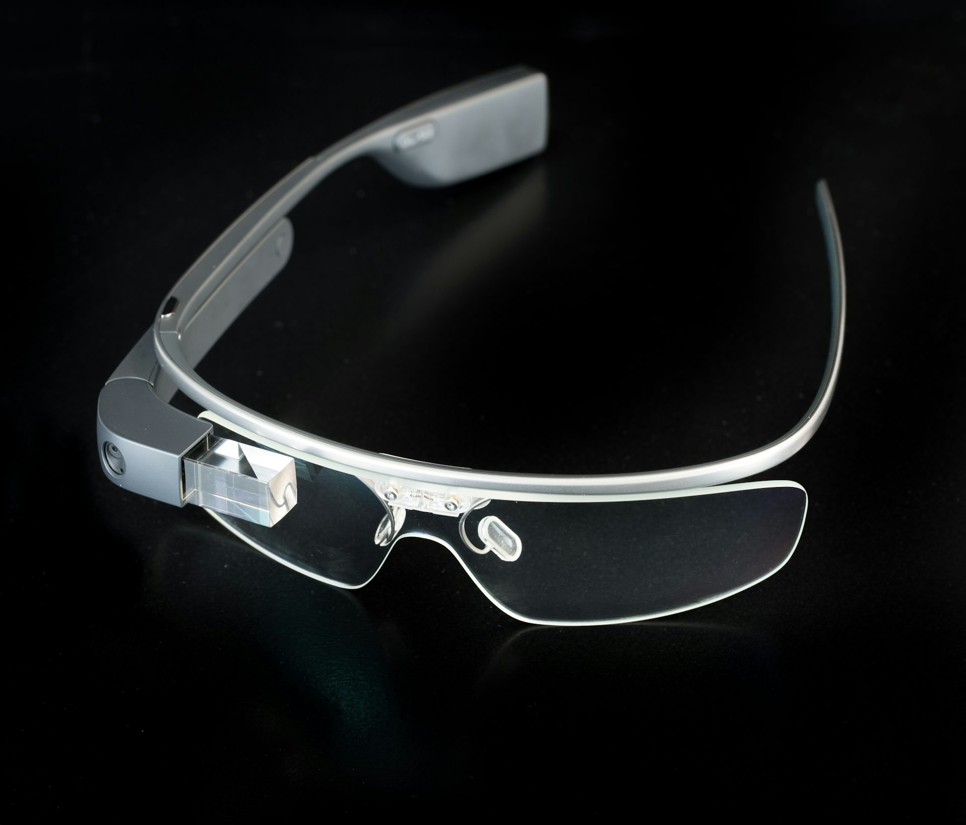 Photograph of the google glass that was released in 2014 on a black surface.