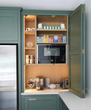 microwave inside a large kitchen cupboard