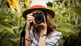 A woman wearing a hat holding the best camera