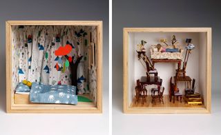 Two side-by-side photos of artistic interpretations of a dolls’ house in square, wooden boxes by several London-based design studios. The first box features multicoloured wallpaper with animals, multicoloured curtains, a black tree trunk, a yellowy-green coloured character in a bed with a blue pillow and sheet, wood flooring and an orange cloud suspended from the ceiling with droplets in different colours. And the second box features light coloured walls, wood flooring and multiple wooden chairs and tables stacked on top of each other with a woman lying on a sofa reading at the very top of the pile. There are books, a teapot, a mug, a jug and glass of juice, a bowl of fruit, a clock and a candelabra on surfaces around the sofa