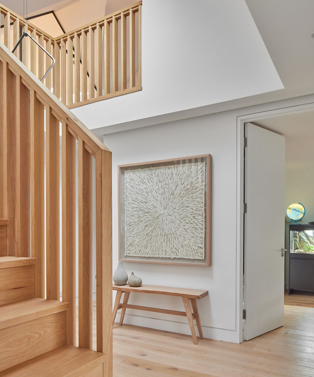 A double height entry hall with a wooden floor and staircase