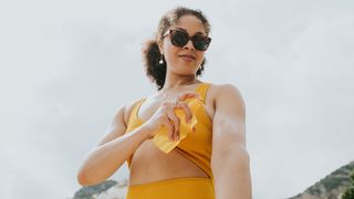 woman spraying on sunscreen