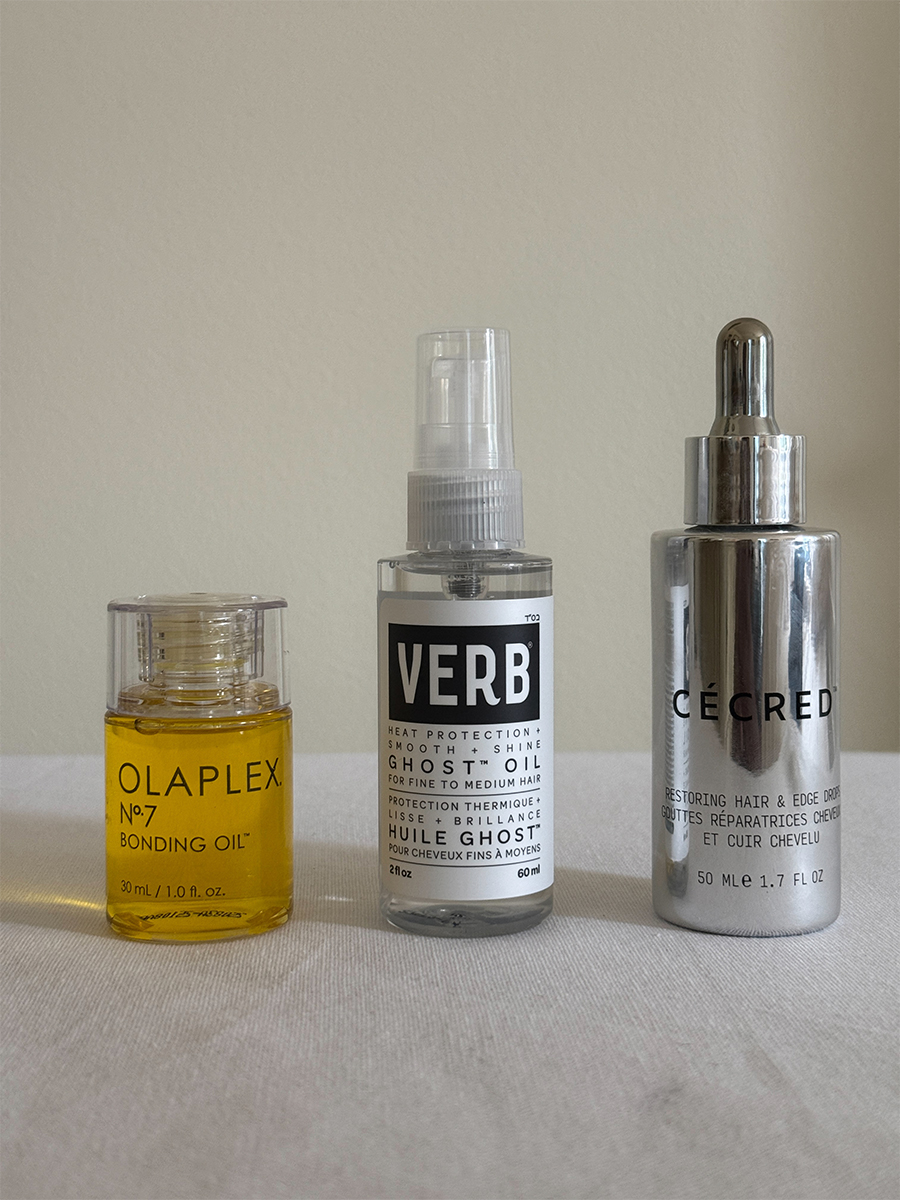 Olaplex&#039;s No.7 Bonding Oil, Verb&#039;s Ghost Oil, and C&amp;eacute;cred Restoring Hair &amp;amp; Edge Drops displayed on a white tabletop