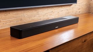 Bose Soundbar 600 underneath a TV in a beige room