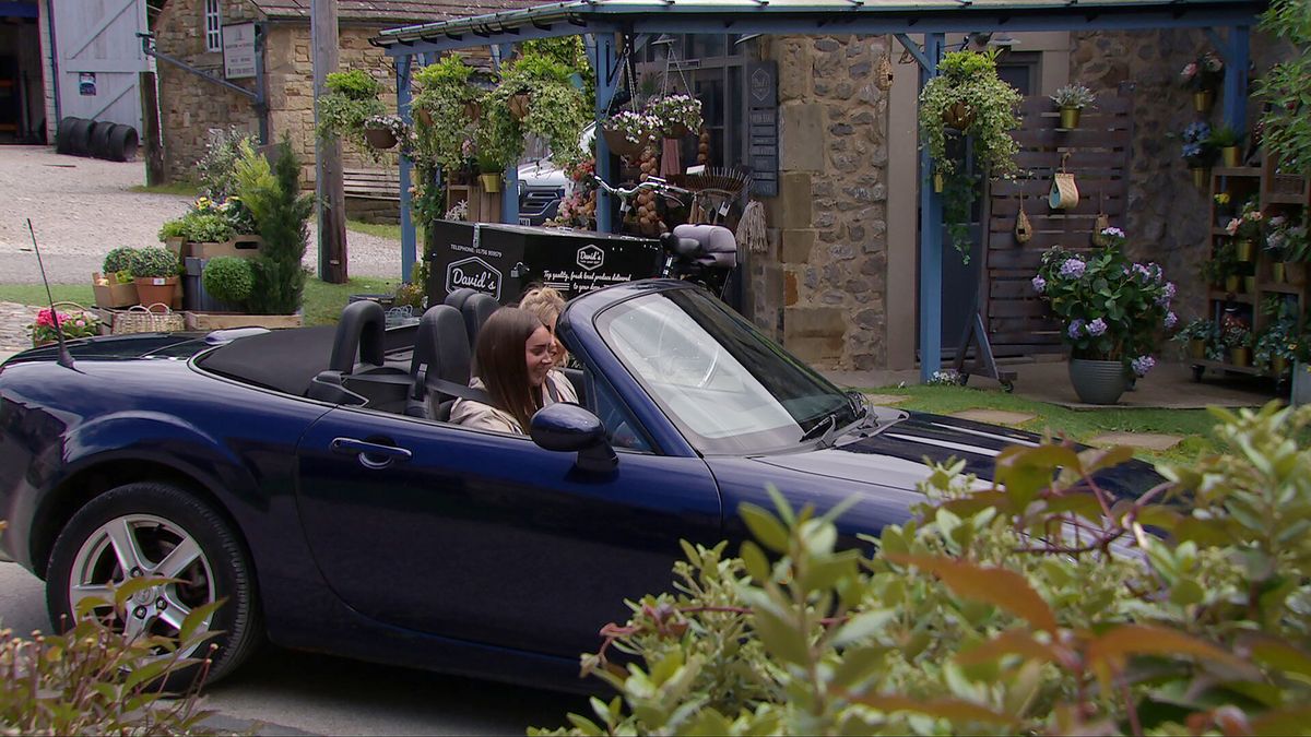 Sarah Sugden behind the wheel of a flash car with Charity Dingle sitting next to her in the passenger seat in Emmerdale.