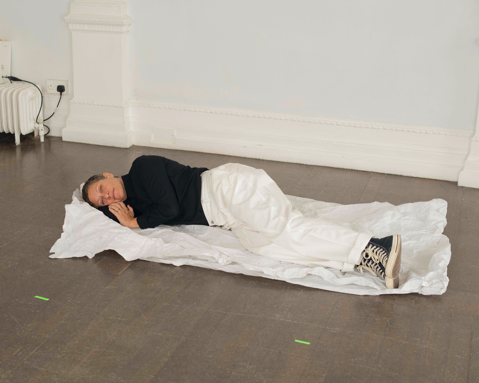woman with short hair standing against a white wall