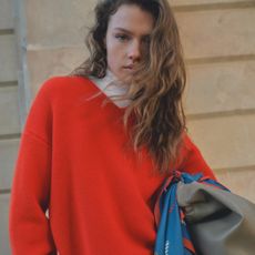 A model wearing a red jumper from H&M.