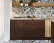 mixed morrocan style patterned tiles in a kitchen with dark wood cabinets, marble countertops and open shelving