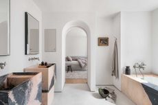 a minimalist bathroom with a pink marble bath