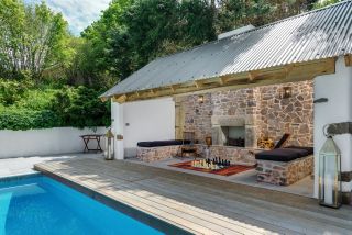 Pool with deck and stone pool house