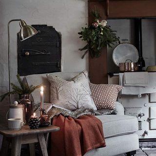 Armchair beside stove with cushions and blanket