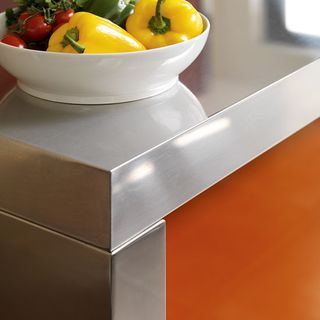 orange kitchen counter with stainless steel worktop and yellow bell pepper