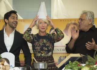Helen Mirren puts on a chef's hat as actors Om Puri, right and Manish Dayal look on, at culinary school le Cordon Bleu for food-themed photo call for the film The One Hundred Foot Journey