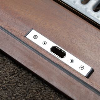 Wooden door with metal strike plate on carpet