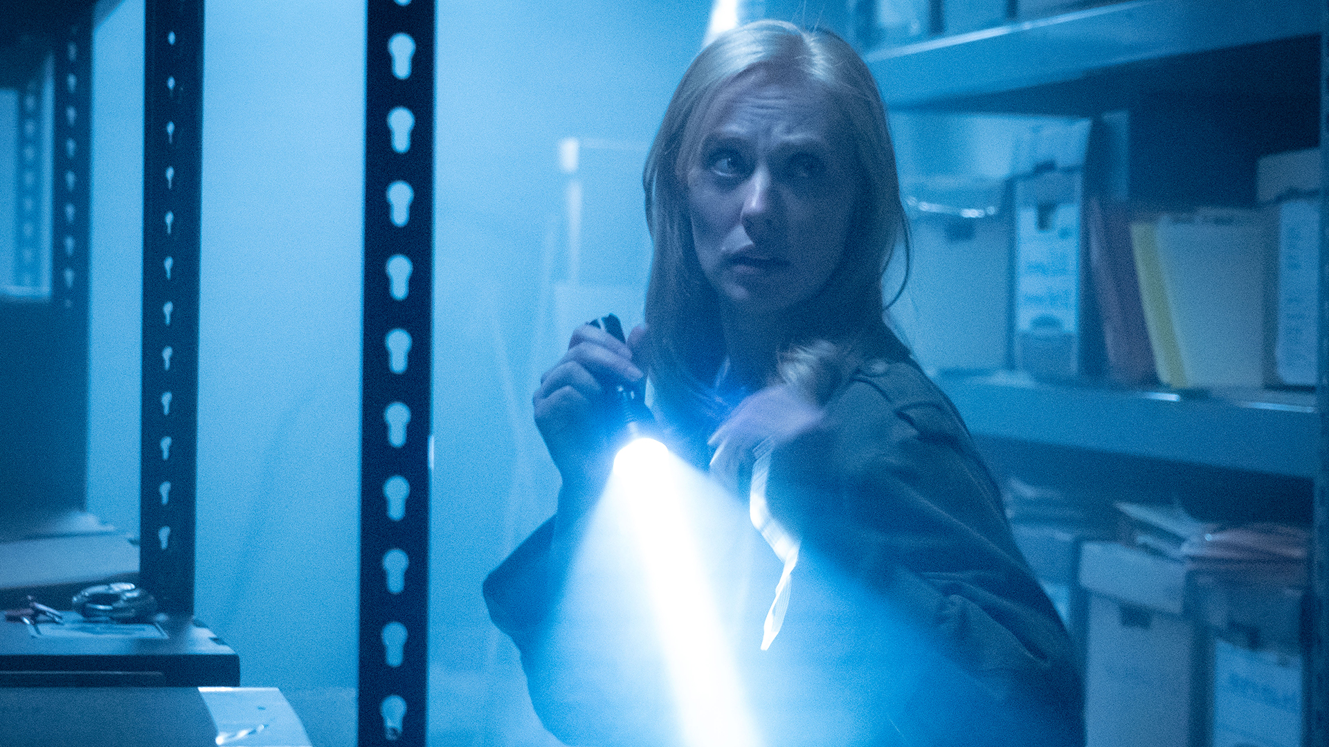 Karen Page in a dark warehouse with her torch turned on in Daredevil: Born Again season 2