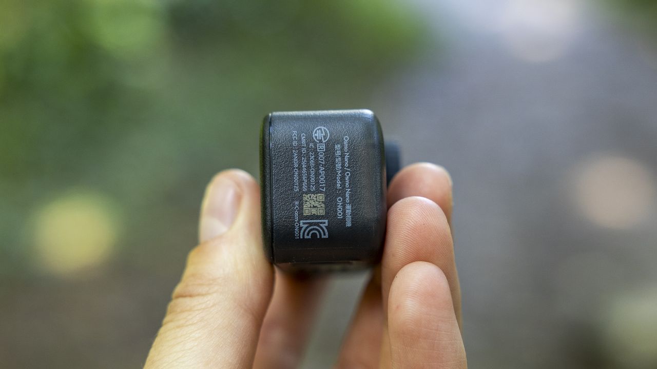A female photographer holding the DJI Osmo Nano action camera