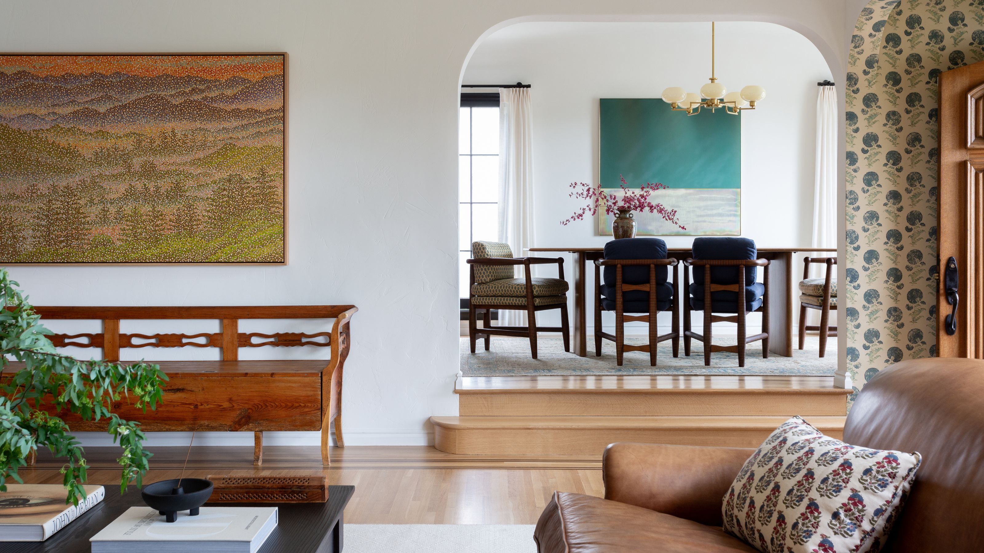 an LA home in Silver Lake with a floral entry that leads into the open plan living room and through an arched opening, into the vintage style dining room