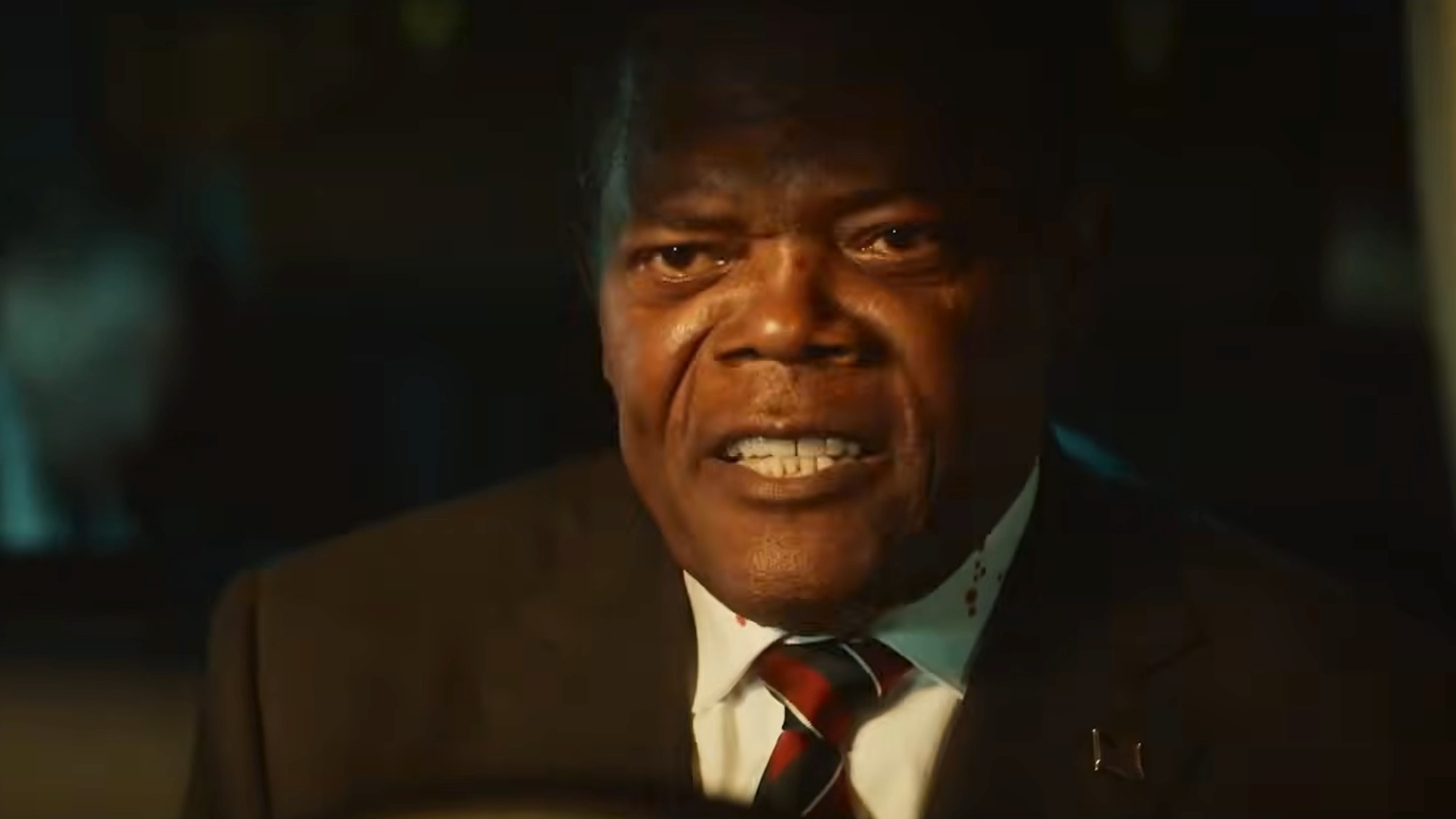 Samuel L. Jackson in a suit and tie, looking very intense while driving a car in The Beast