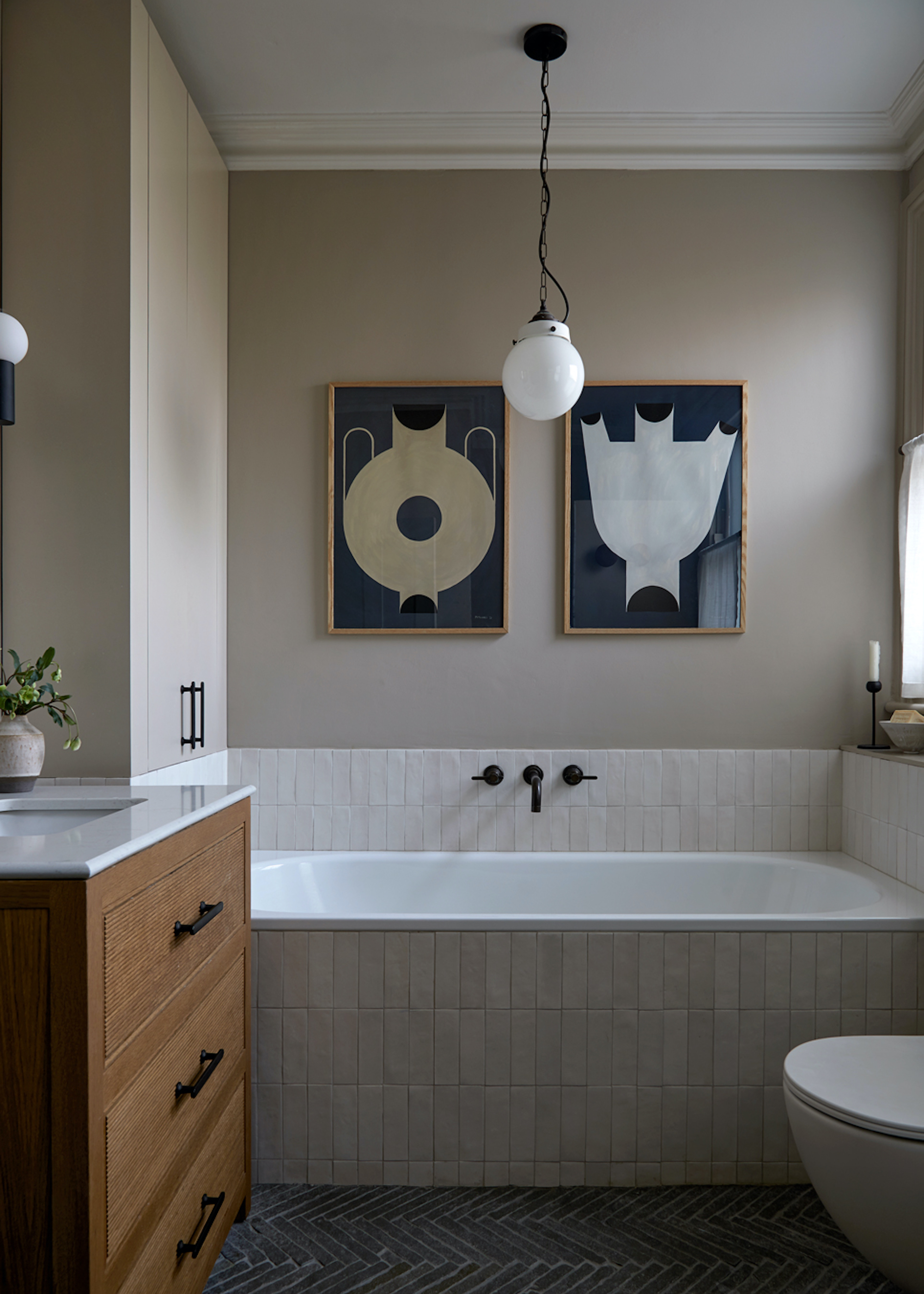 bathroom with tiled bath and wood vanity and bold prints