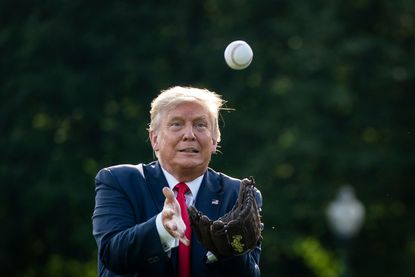 Donald Trump tries to catch a baseball.