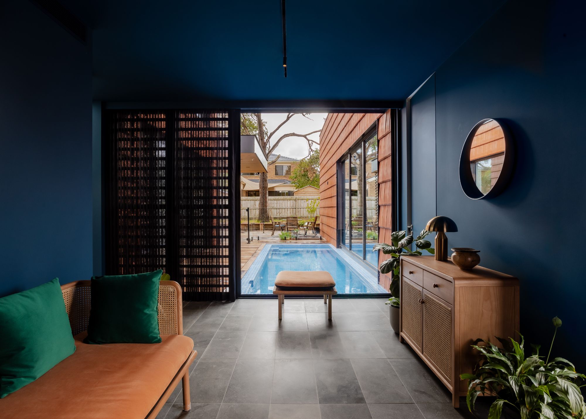 A living room with a view of the pool and outdoor