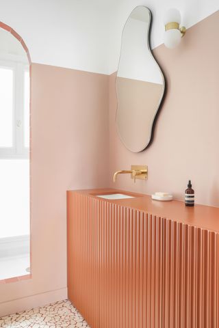 A small bathroom with a deep toned vanity and wall paint from the same family