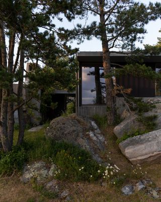 Cabin Lillesand, a norwegian summer house out of wood and its timber interior looking out to waterside nature views through large windows