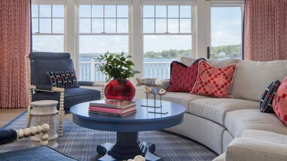 living room with view of lake and curved white sofa and blue chairs