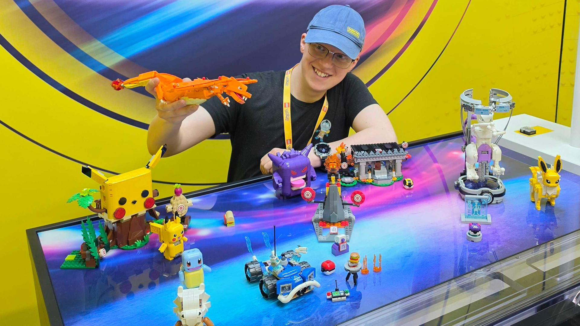 Hamish plating with a Lego Charizard surrounded by Lego Pokémon.