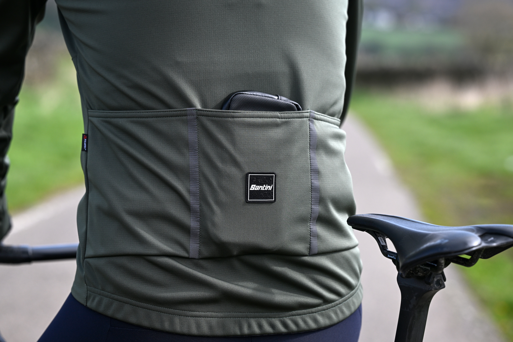 close up of the three rear pockets on a dark green jacket