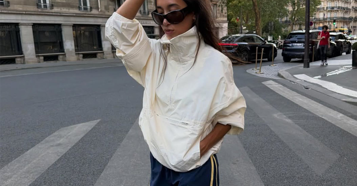 Woman wearing a white funnel-neck jacket.