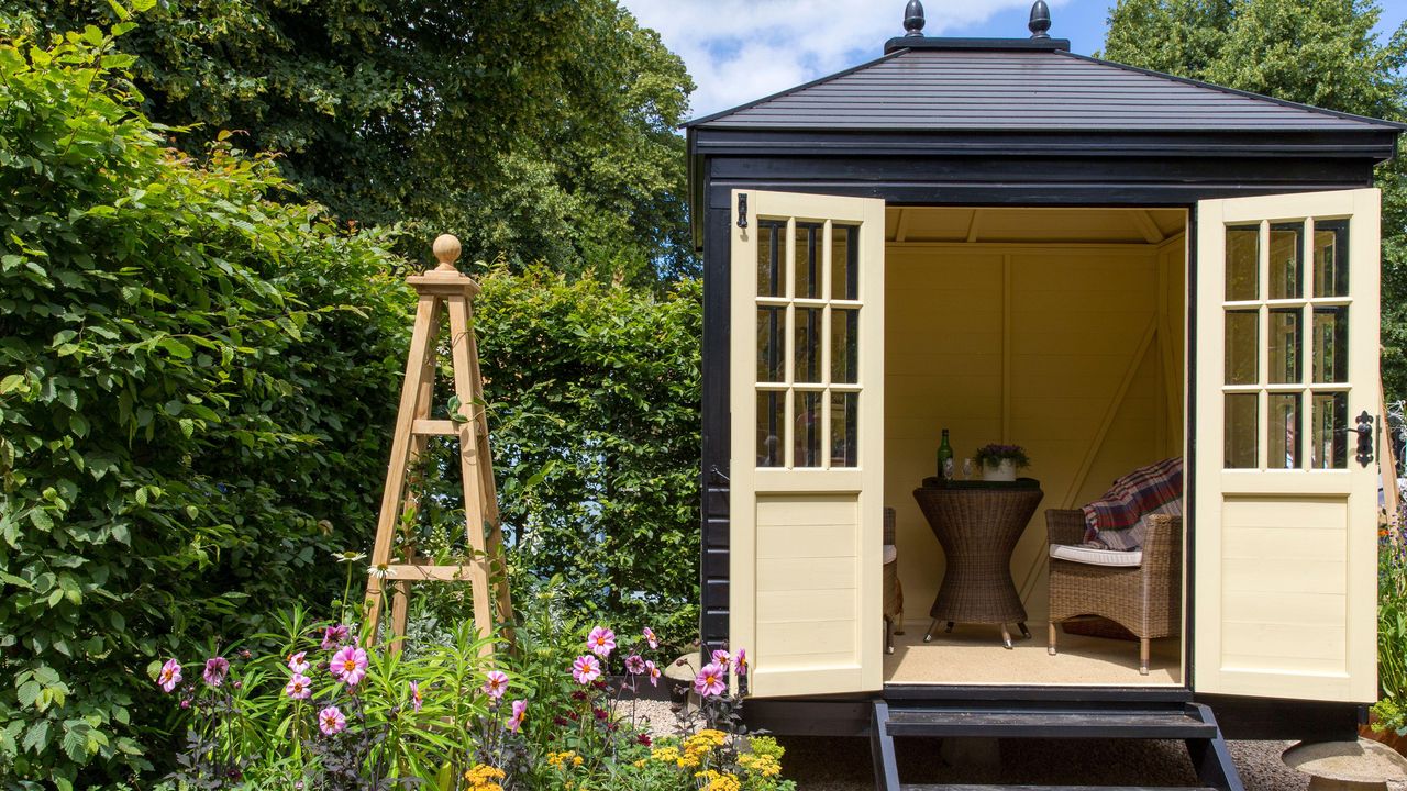 A small English cottage garden with Summerhouse Shepherds Hut in gravel garden