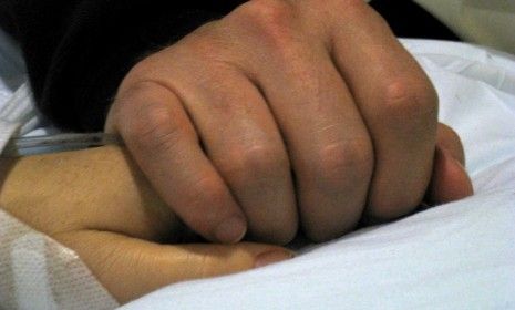 Gabrielle Giffords&amp;#039; husband Mark Kelly holds his wife&amp;#039;s hand in the Tucson hospital room. The extent of the congresswoman&amp;#039;s injuries are still unknown.